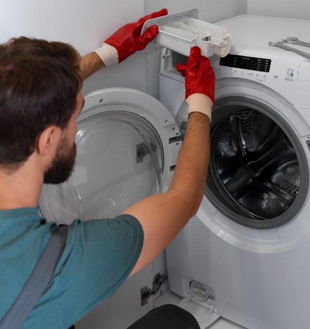 Técnico reparando el panel de una lavadora de carga frontal